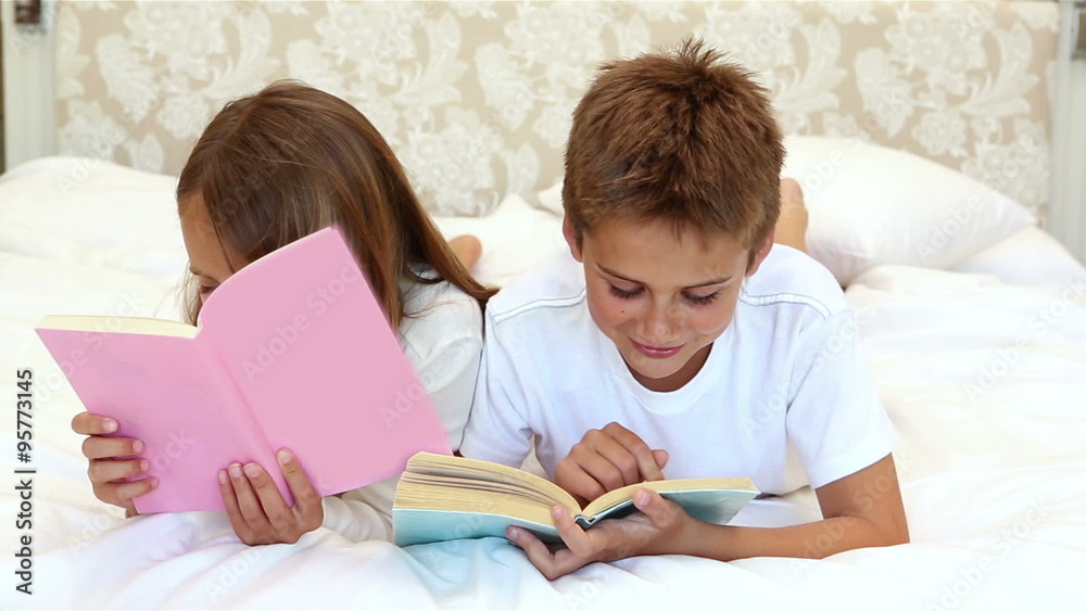  Children reading a book on the bed