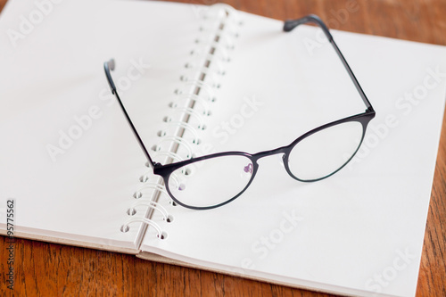 Eyeglasses on opened spiral notebook