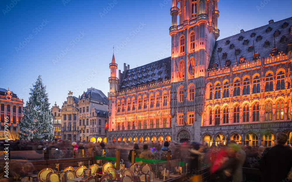 Lights show in Grand Place of Brussels Belgium and a huge Christmas tree with a crowd of unidentified people enjoying the celebration atmosphere