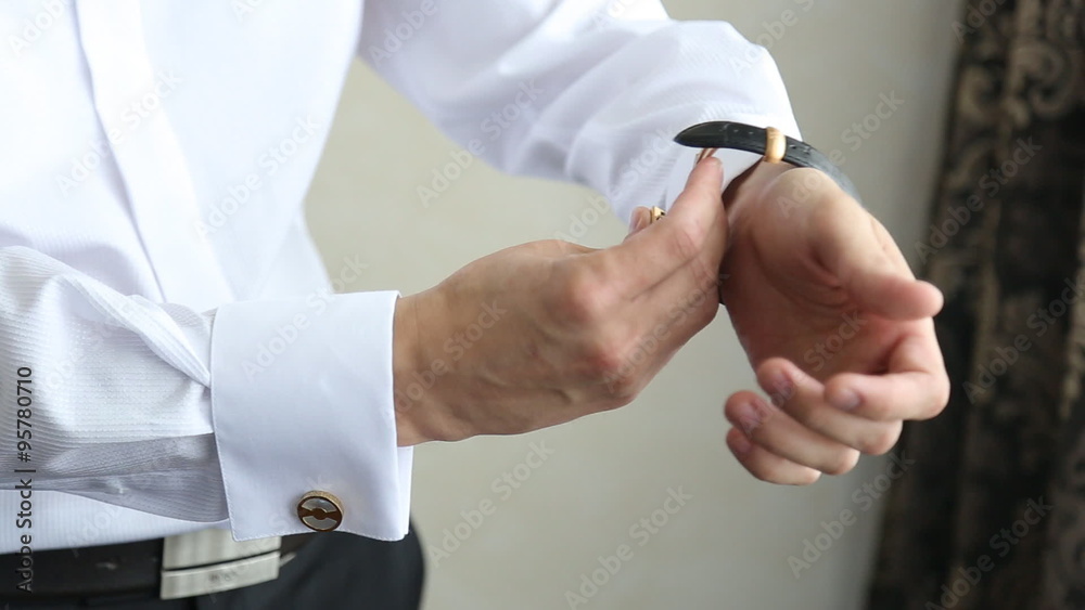man puts on watch