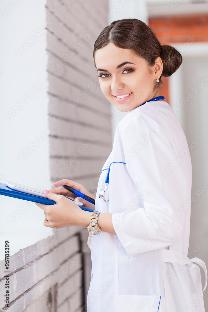 Female doctor looking at medical records on tablet computer at hospital Female doctor looking at medical records on tablet computer at hospital