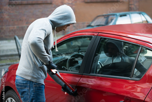Thief Using Crowbar To Open Car's Door