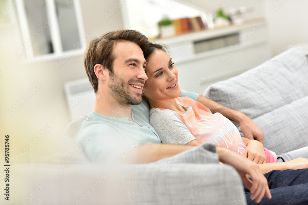 Fototapeta premium Couple relaxing in sofa and watching tv