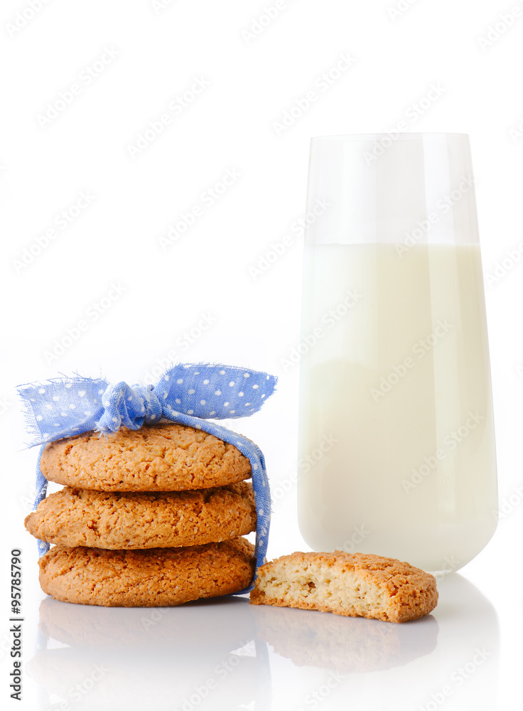 Stack of three homemade oatmeal cookies tied with blue ribbon in small white polka dots, half of cookie and glass of milk, isolated on white background Stack of three homemade oatmeal cookies tied with blue ribbon in small white polka dots, half of cookie and glass of milk, isolated on white background