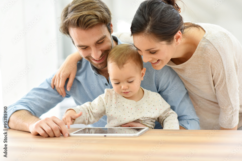 Parents with baby girl playing with digital tablet Parents with baby girl playing with digital tablet