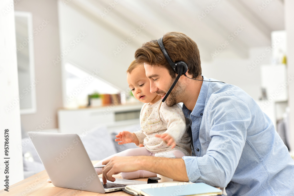 Busy businessman working from home and watching baby Busy businessman working from home and watching baby