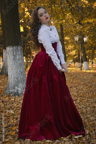 Woman dressed in a retro-style on the autumn alley