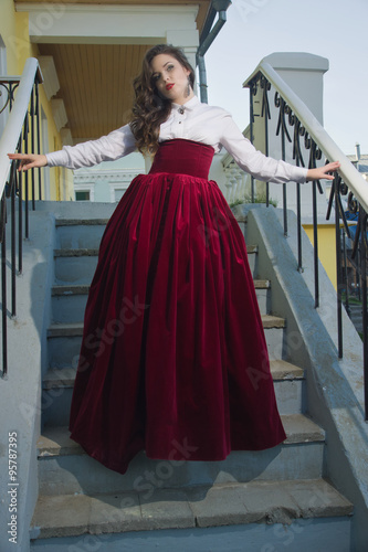 Girl in vintage dress on the stairs