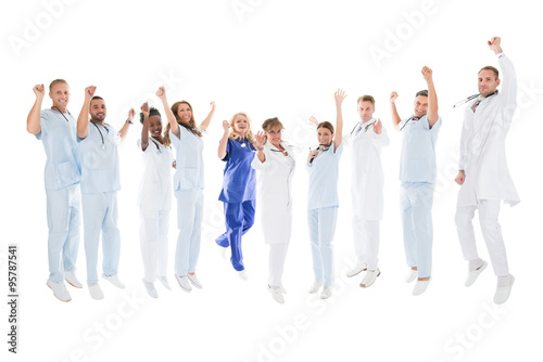 Multiethnic Medical Team Standing With Arms Raised