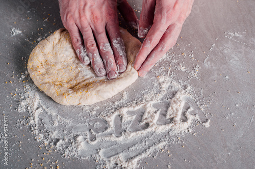 Man making dough for pizza photo