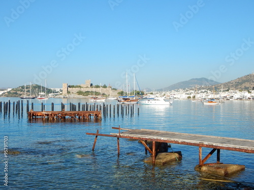 Ein alter, kaputter Holzsteg im Hafen von Bodrum, das St. Peter Kastell im Hintergund