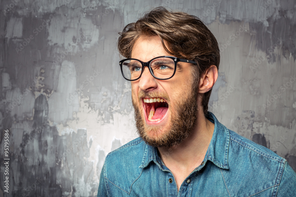 Young man screaming with widely opened mouth Young man screaming with widely opened mouth
