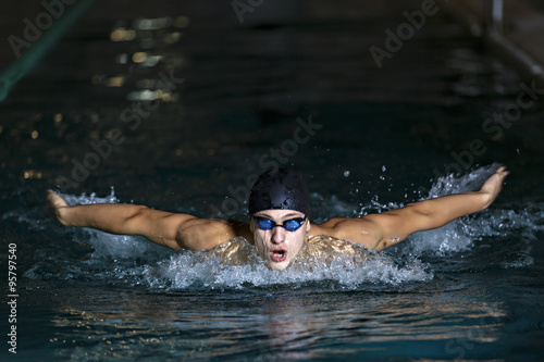 dynamic and fit swimmer in cap breathing performing the butterfl © czamfir