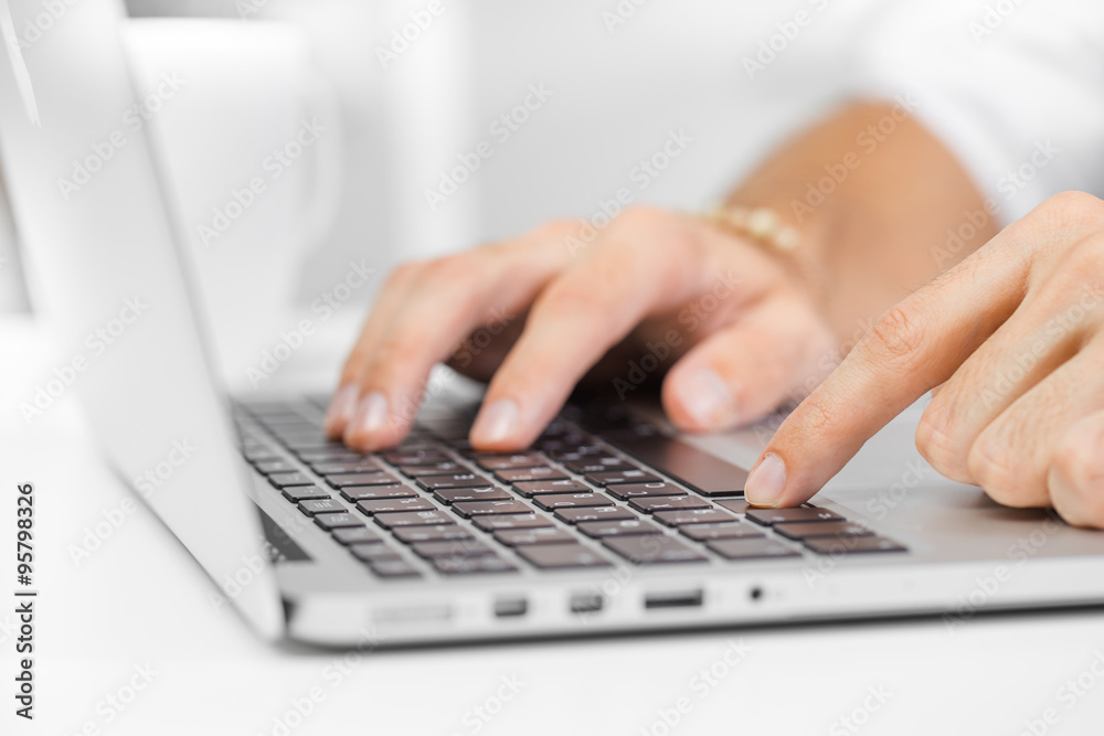 Cropped shot of a man's hands using a laptop at home Cropped shot of a man's hands using a laptop at home