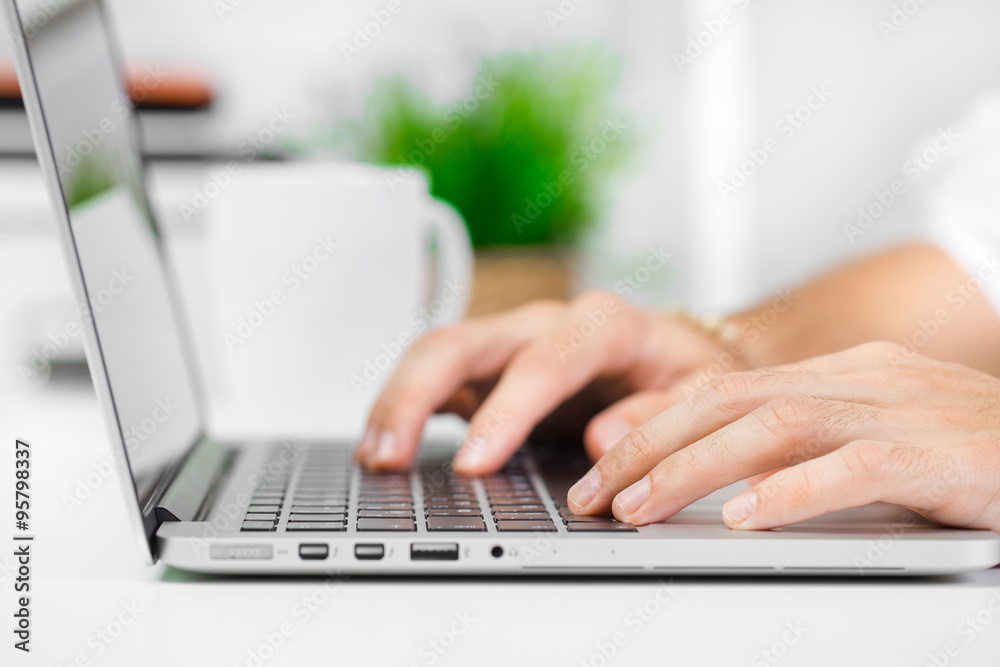 Cropped shot of a man's hands using a laptop at home Cropped shot of a man's hands using a laptop at home