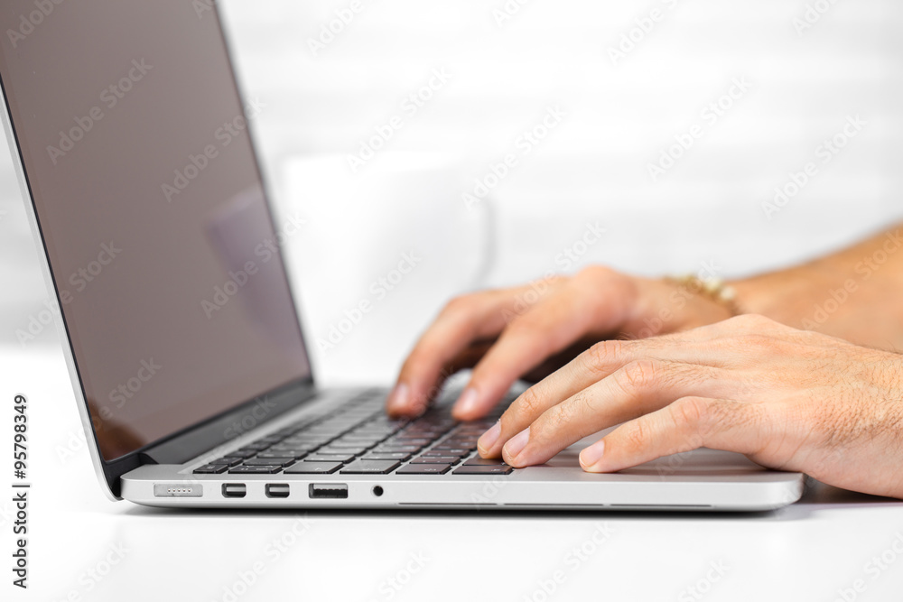 Cropped shot of a man's hands using a laptop at home Cropped shot of a man's hands using a laptop at home