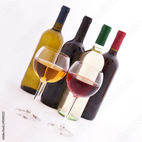 Glasses and bottles of wine unusually on white background.
