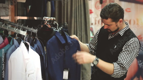 Portrait of a young man shopping for clothes at store