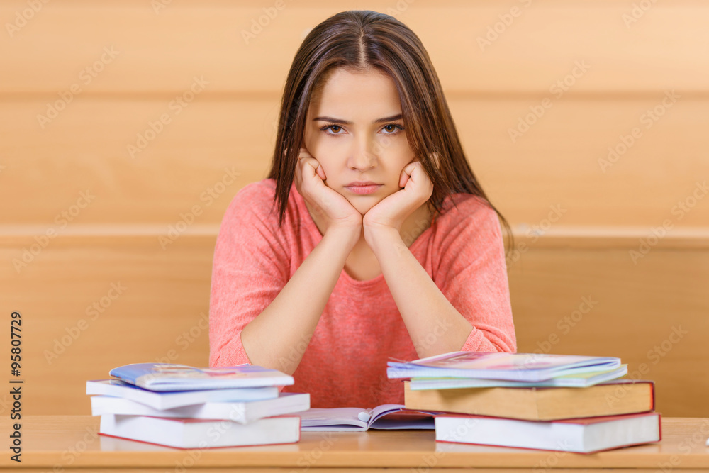Young student loaded with books and manuals. Young student loaded with books and manuals.