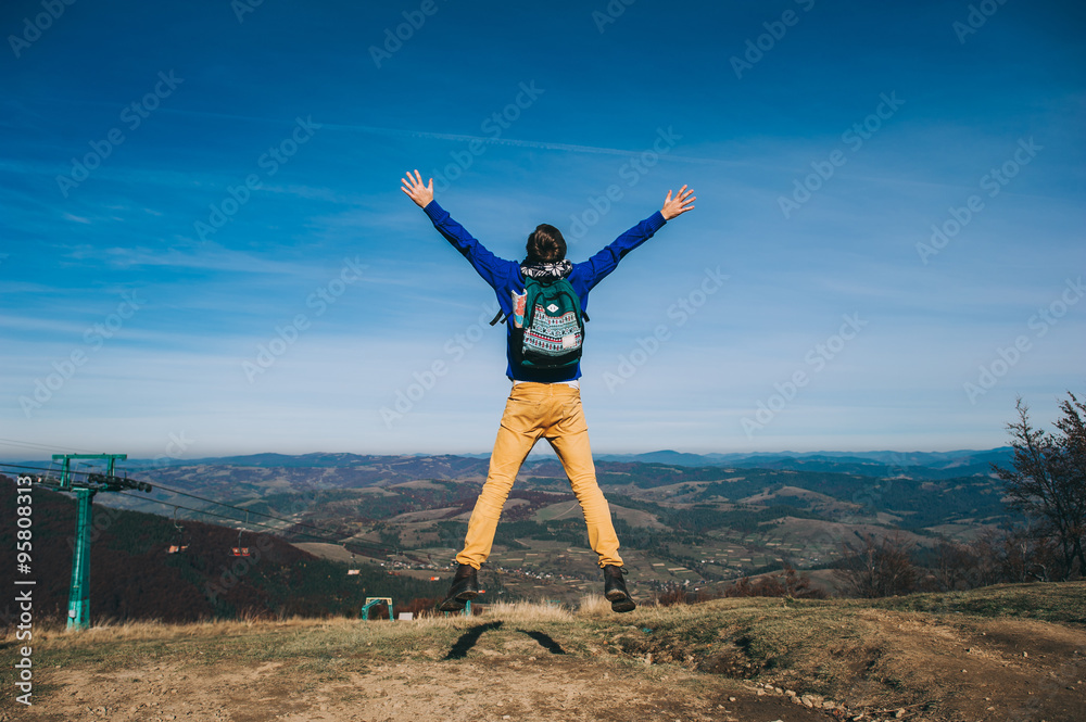 Handsome young man standing on a rock, enjoying the view Handsome young man standing on a rock, enjoying the view