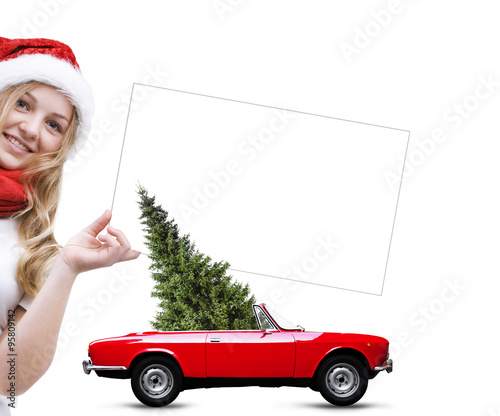Mädchen mit Weihnachtsmütze und Christbaum im Auto