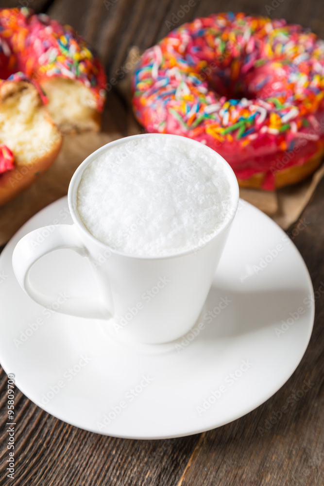 Cappuccino and donuts on a wooden table Cappuccino and donuts on a wooden table