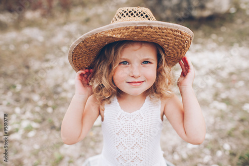 happy little girl wearing a hat outdoors