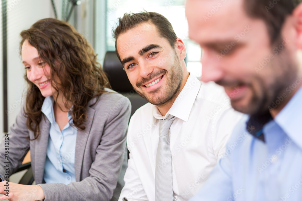 Young attractive businessman working at the office with associat Young attractive businessman working at the office with associat