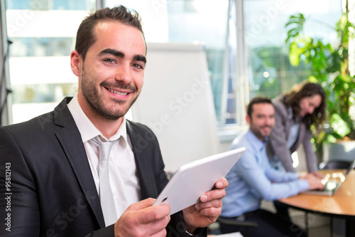 Young attractive businessman working at the office with associat © Production Perig