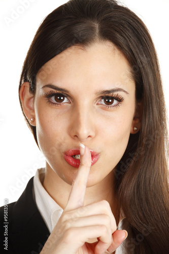 A woman puts her finger to her mouth as if saying "shhh" or be quiet.