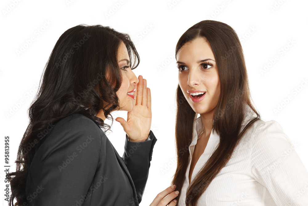 Woman in blue business suit tells a secret to woman in white. Woman in blue business suit tells a secret to woman in white.