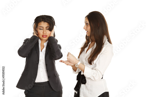 One woman with her hands over her ears while being "talked at" by another woman.