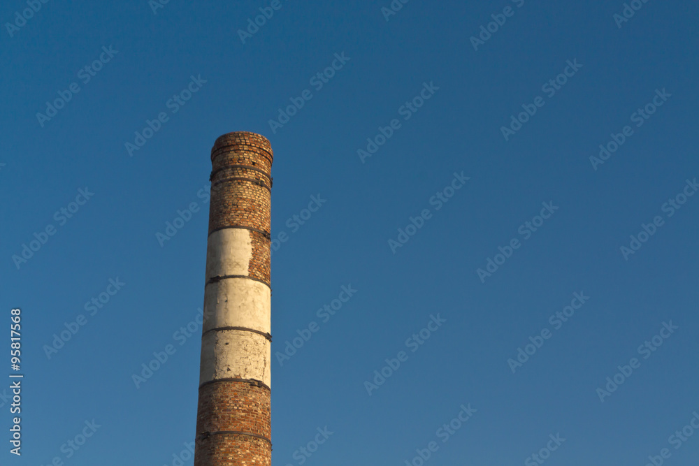 Old brick factory chimney and blue sky.
