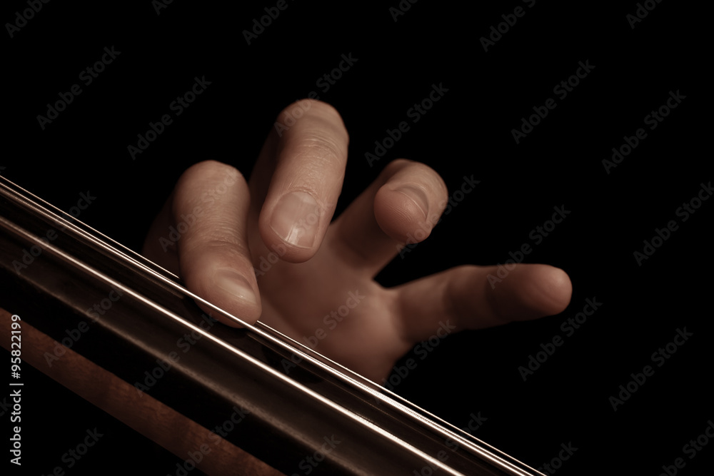 The fingers on the strings of the cello on a black background The fingers on the strings of the cello on a black background