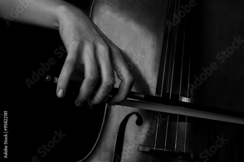 Fototapeta Hand of a woman playing the cello in black and white