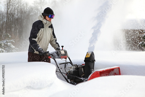 A man works snow blowing machine photo