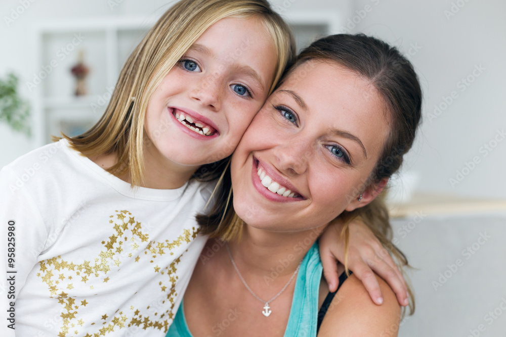 Young mother and daughter looking at camera at home. Young mother and daughter looking at camera at home.