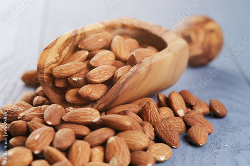 roasted almonds on blue wooden table with scoop