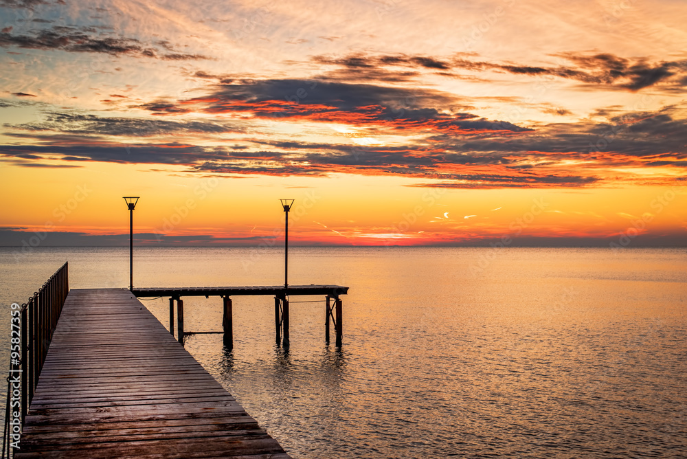 Wooded bridge in the port between sunrise.