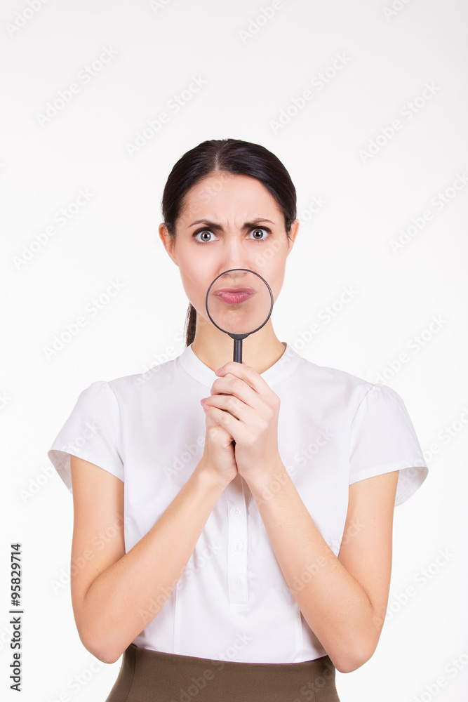Funny portrait of girl holding magnifier near her face. White background Funny portrait of girl holding magnifier near her face. White background