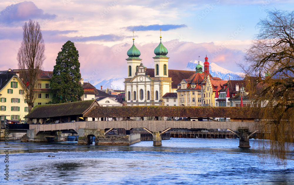 Lucerne, Switzerland, view over the Reuss river to the wooden Spreuer bridge and Alps mountains
