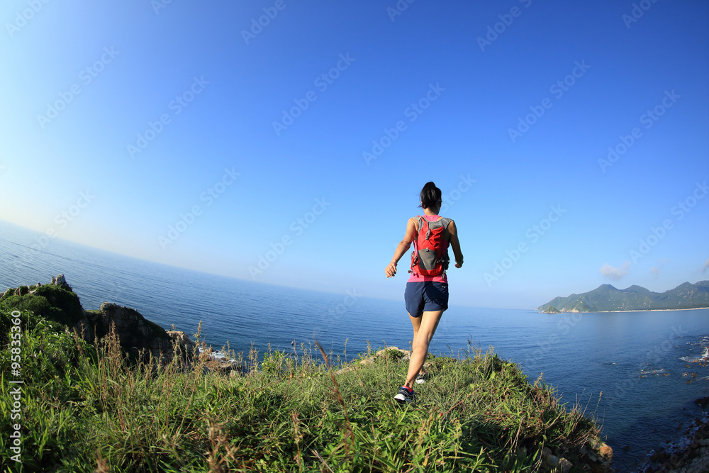 young fitness woman trail runner running on seaside mountain young fitness woman trail runner running on seaside mountain