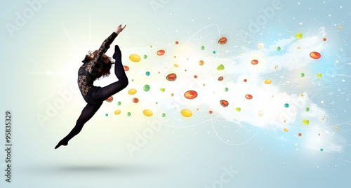 Beautiful woman jumping with colorful gems and crystals on the b