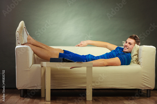 Foto Young man relaxing on couch