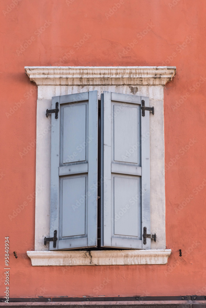 Fototapeta premium Fenster mit hellblauen Fensterläden, rote Wand