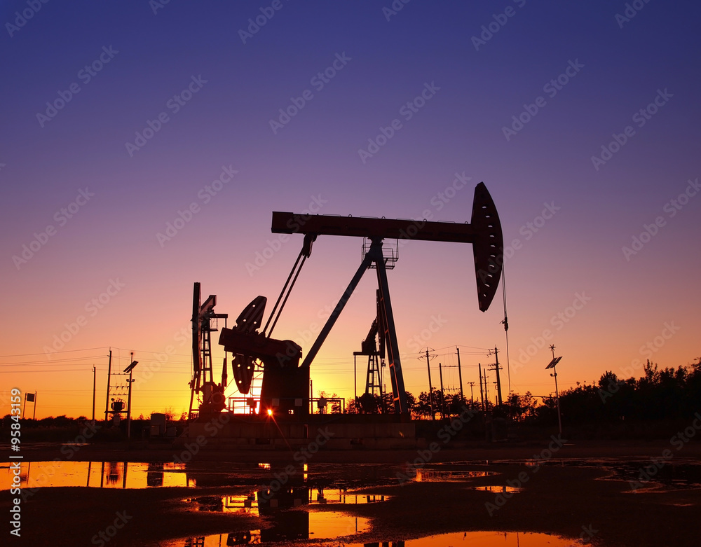 Oil field scene, the evening of beam pumping unit in silhouette Oil field scene, the evening of beam pumping unit in silhouette