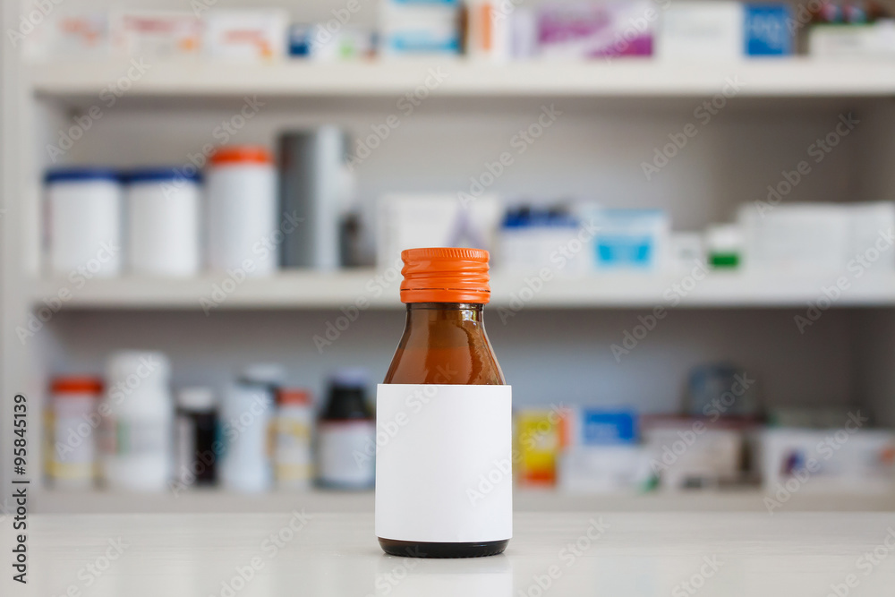Blank white label of medicine bottle with blur shelves of drug i Blank white label of medicine bottle with blur shelves of drug i