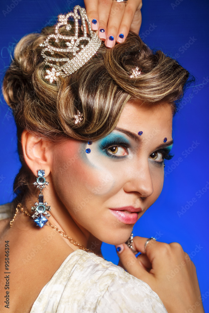 Girl with face art, jewelry, hair and tiara.