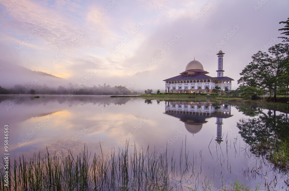 Obraz premium Reflection of a beautiful mosque during blue hour.
