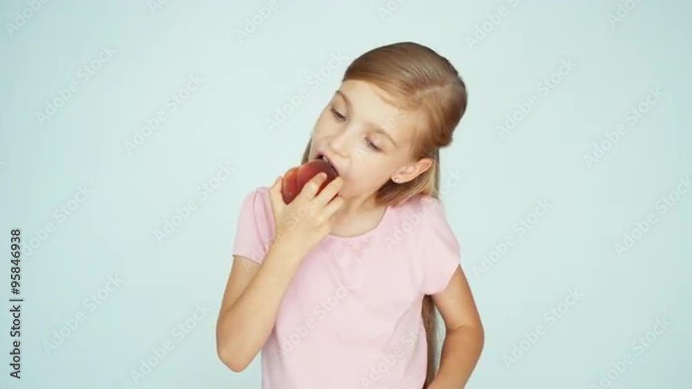 Girl eating peach and kissing it on the white background. Thumb up. Ok Girl eating peach and kissing it on the white background. Thumb up. Ok